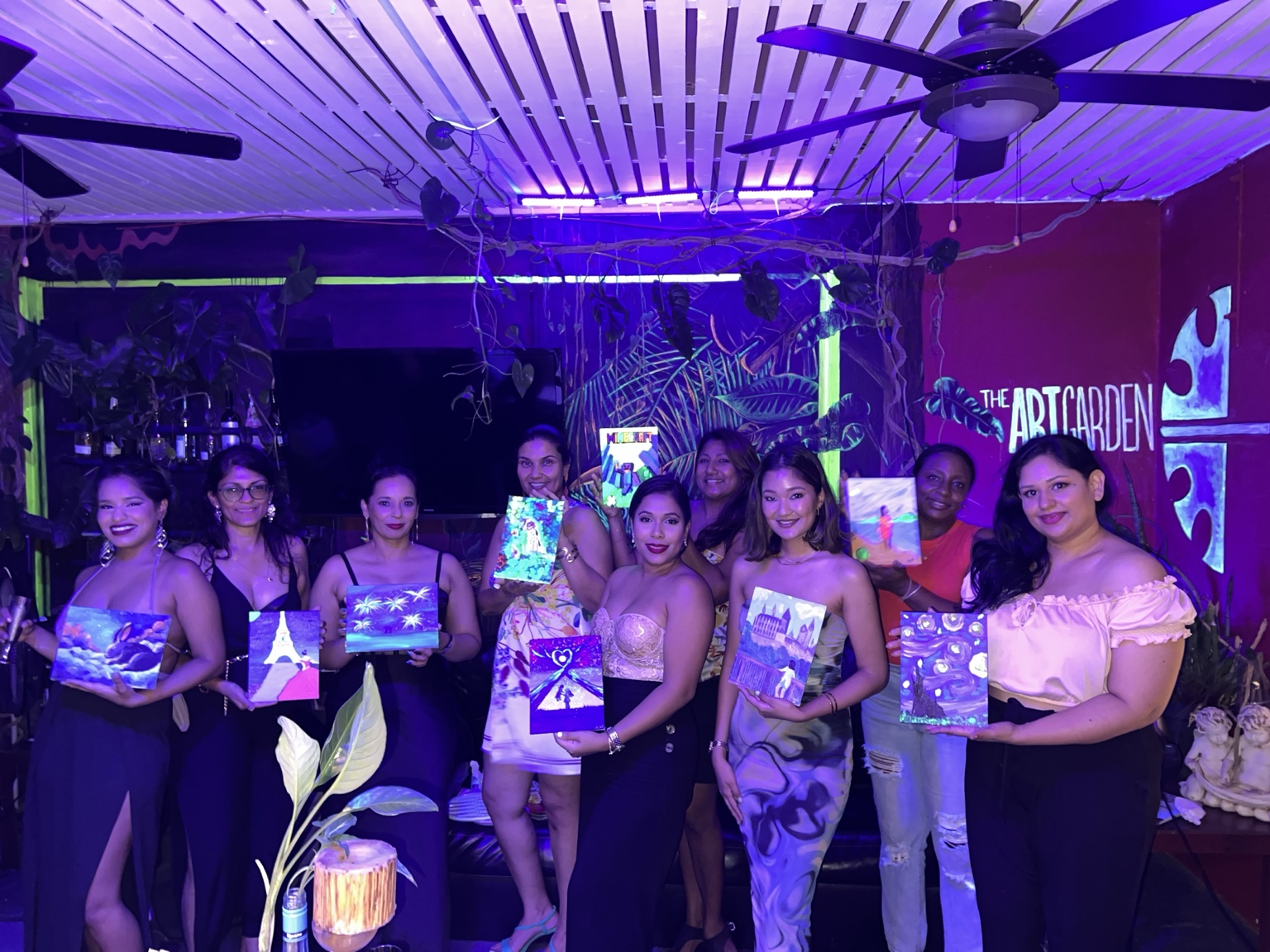Guests holding their paintings at The Art Garden